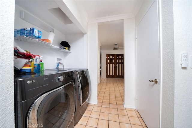 washroom featuring light tile patterned flooring, crown molding, and independent washer and dryer