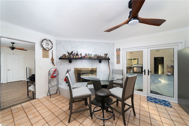 dining area with french doors, light wood-type flooring, ornamental molding, and ceiling fan