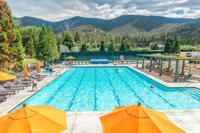 view of swimming pool with a mountain view and a patio