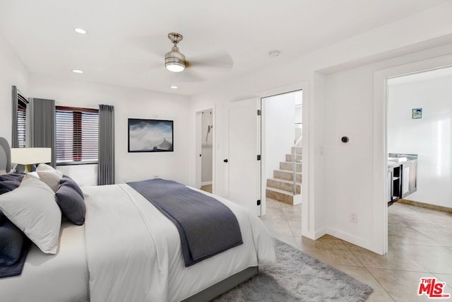 tiled bedroom with ensuite bath and ceiling fan