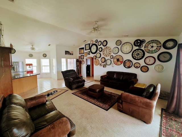 living room featuring vaulted ceiling, light tile patterned floors, and ceiling fan