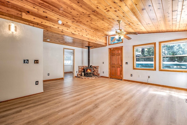 interior space featuring light hardwood / wood-style flooring, a wood stove, vaulted ceiling, and wooden ceiling