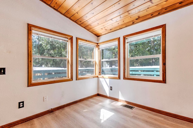 spare room featuring wooden ceiling, a healthy amount of sunlight, and lofted ceiling