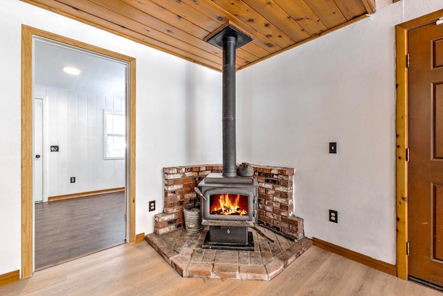 interior details with a wood stove, hardwood / wood-style flooring, and wooden ceiling