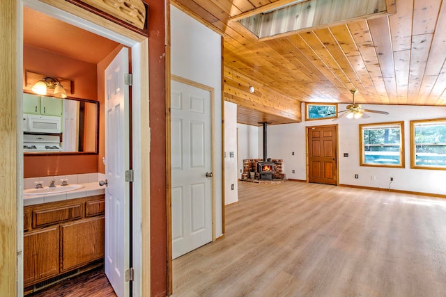 corridor featuring wood ceiling, light wood-type flooring, vaulted ceiling, and sink