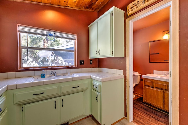 kitchen with tile counters, light hardwood / wood-style floors, sink, and wood ceiling