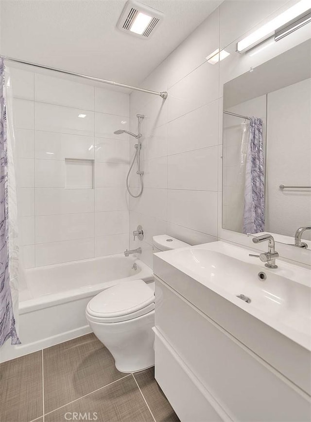 bathroom with visible vents, toilet, vanity, and shower / tub combo with curtain