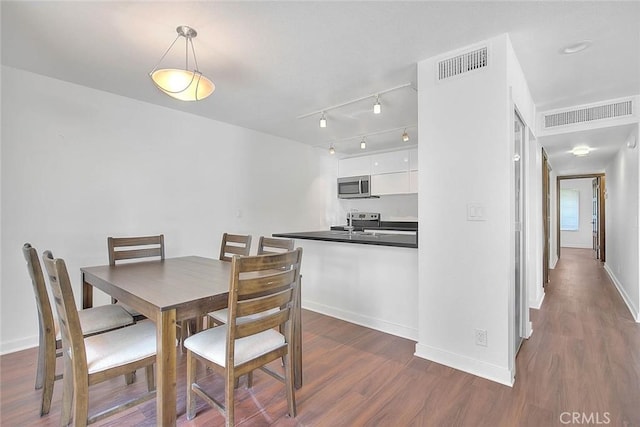 dining room featuring visible vents, baseboards, and dark wood-type flooring