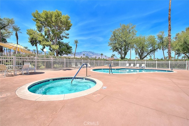 view of pool featuring a patio, a mountain view, and a community hot tub