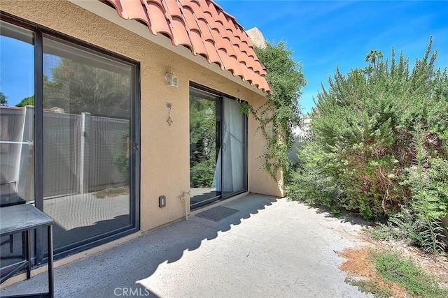 view of home's exterior with stucco siding and a tile roof