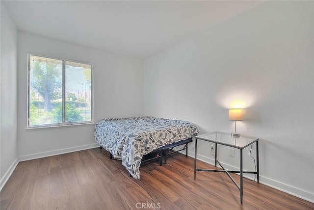 bedroom featuring wood finished floors and baseboards