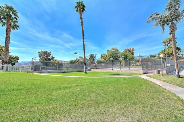 view of tennis court with a lawn