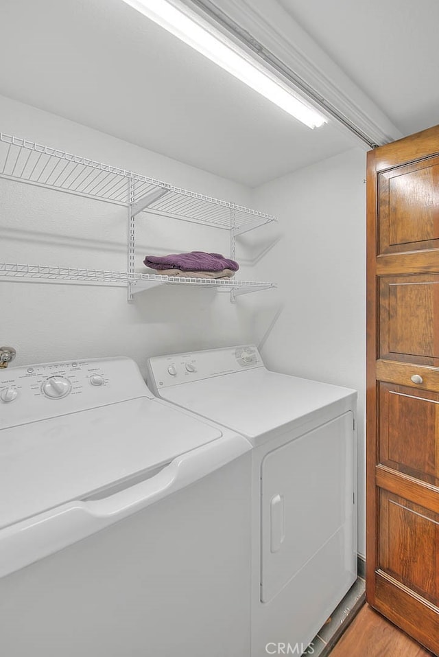 washroom with light hardwood / wood-style flooring and washing machine and dryer