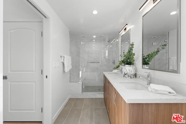 bathroom featuring tile patterned flooring, a shower with shower door, and vanity