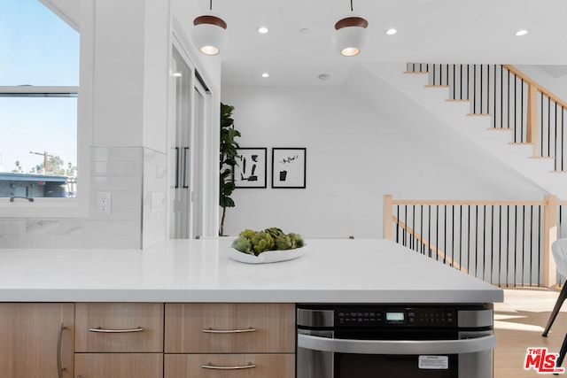 kitchen featuring lofted ceiling, light wood-type flooring, and tasteful backsplash