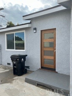 view of exterior entry featuring a patio area