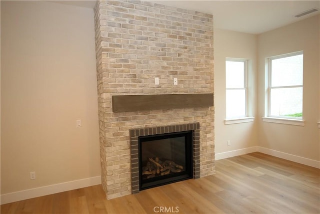 interior details featuring wood-type flooring and a brick fireplace