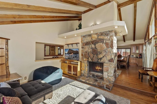 living room featuring hardwood / wood-style flooring, high vaulted ceiling, a fireplace, and beamed ceiling