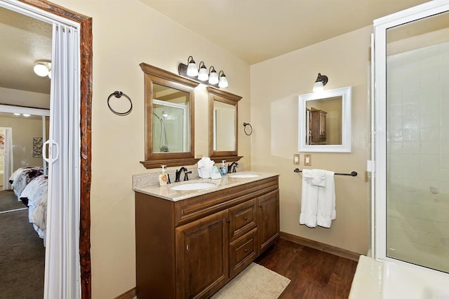 bathroom with walk in shower, vanity, and hardwood / wood-style flooring