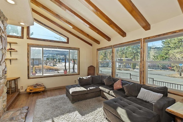 sunroom / solarium featuring vaulted ceiling with beams and plenty of natural light