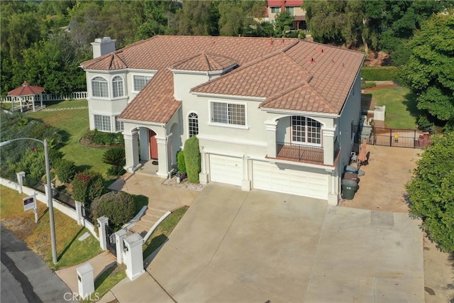 mediterranean / spanish house featuring a garage and a front lawn