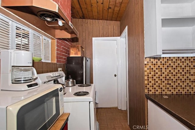 kitchen with wood walls, parquet flooring, fridge, white range with electric cooktop, and wooden ceiling