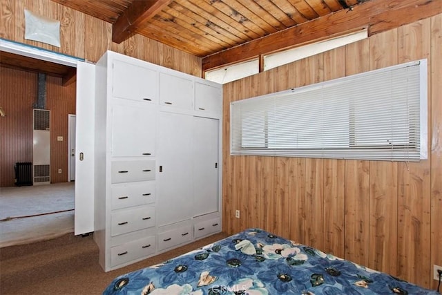 unfurnished bedroom featuring wooden ceiling, carpet, wood walls, and beamed ceiling