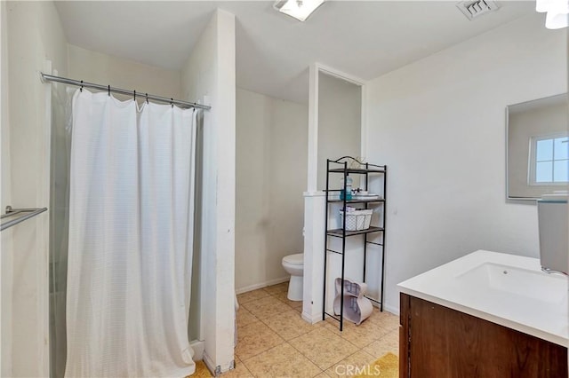 bathroom featuring tile patterned flooring, vanity, toilet, and curtained shower