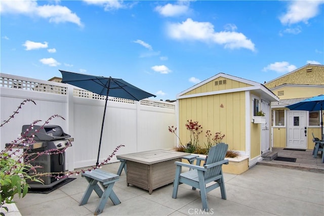 view of patio / terrace with area for grilling, a shed, and an outdoor fire pit