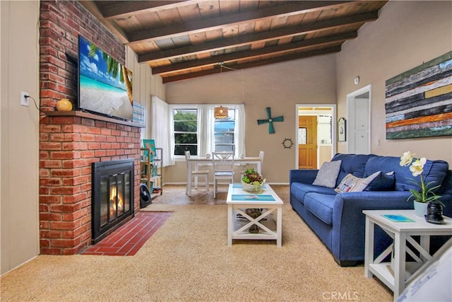 carpeted living room featuring vaulted ceiling with beams, a brick fireplace, and wood ceiling