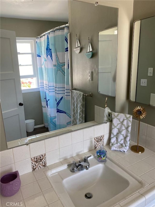 bathroom with sink and tasteful backsplash