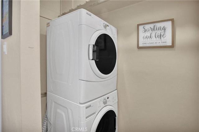 clothes washing area featuring stacked washer / dryer