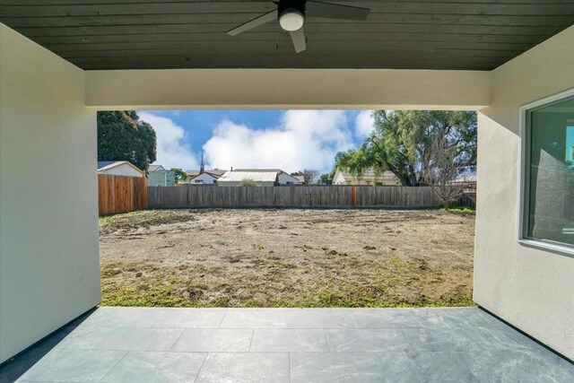 view of yard featuring ceiling fan and a patio area