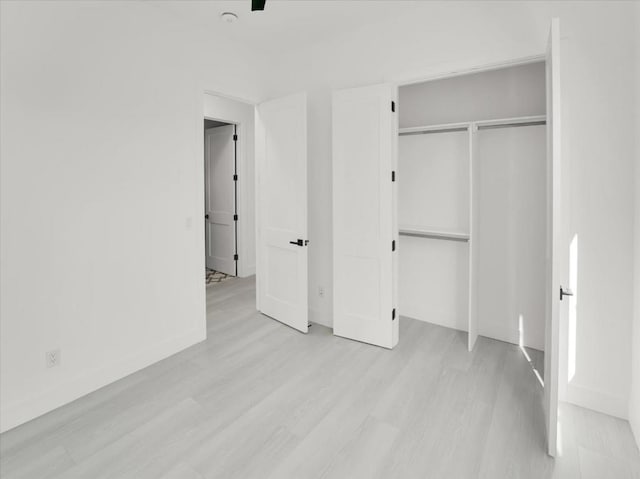 unfurnished bedroom with light hardwood / wood-style floors and a closet