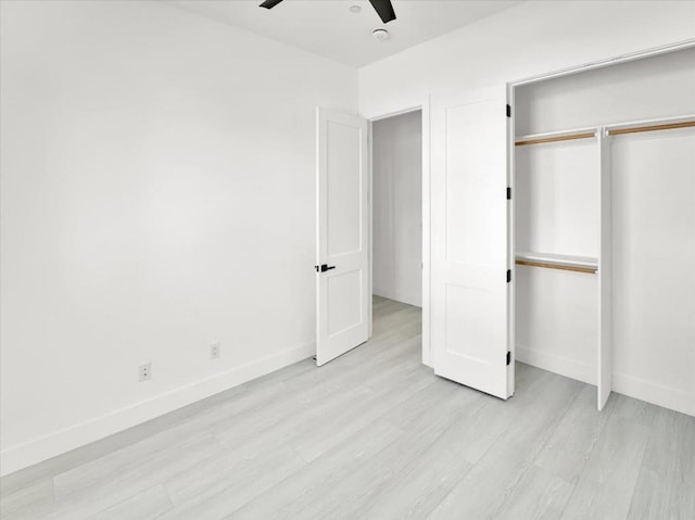 unfurnished bedroom with ceiling fan, a closet, and light hardwood / wood-style flooring