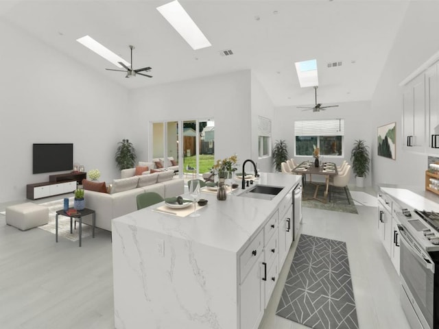 kitchen with a center island with sink, high vaulted ceiling, light stone countertops, white cabinets, and sink