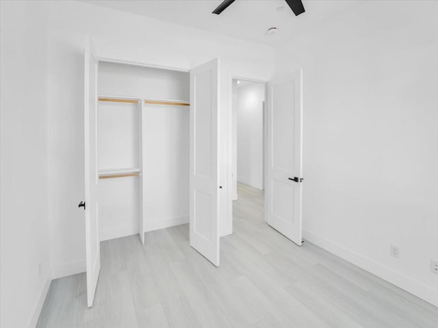 unfurnished bedroom with ceiling fan, a closet, and light hardwood / wood-style floors