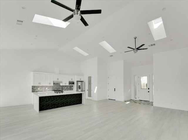 unfurnished living room with ceiling fan, light hardwood / wood-style floors, and high vaulted ceiling