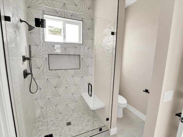 bathroom featuring a shower with shower door, tile patterned flooring, and toilet