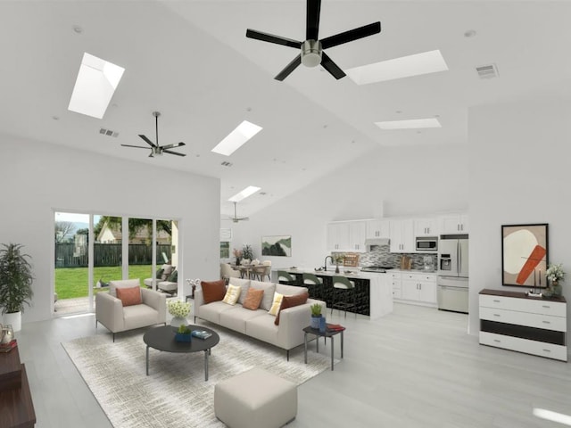 living room with high vaulted ceiling, ceiling fan, and light wood-type flooring