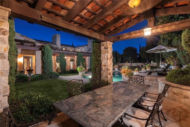 patio terrace at dusk with pool water feature, a yard, and an outdoor bar