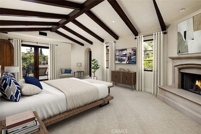 carpeted bedroom featuring lofted ceiling with beams, a premium fireplace, multiple windows, and french doors