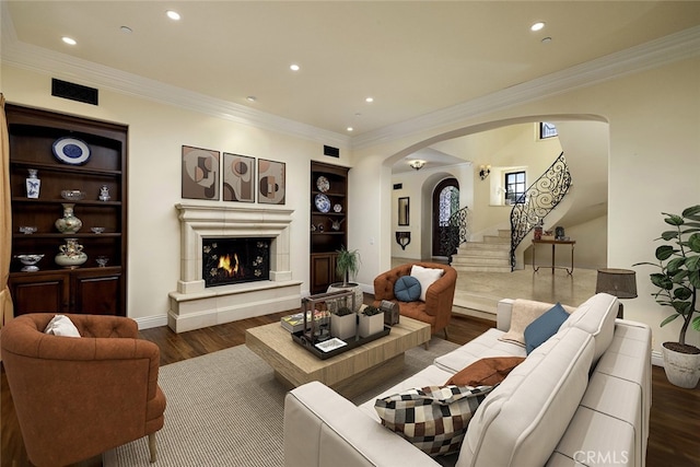 living room featuring ornamental molding, dark hardwood / wood-style flooring, and built in shelves