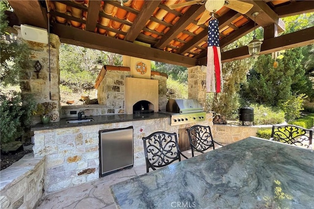 view of patio featuring exterior kitchen, a gazebo, a grill, and sink