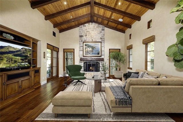 living room featuring a stone fireplace, a healthy amount of sunlight, and wood ceiling