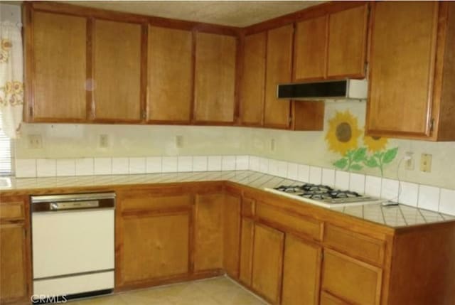 kitchen with white appliances, tile countertops, and extractor fan