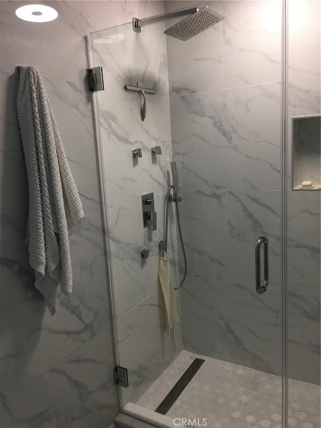 bathroom featuring a shower with door