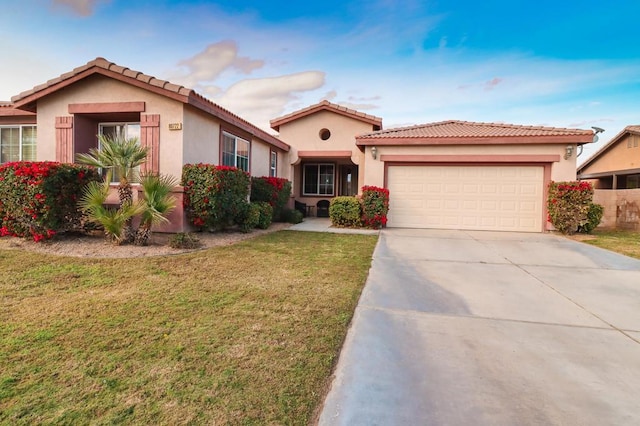 mediterranean / spanish home with a front lawn and a garage