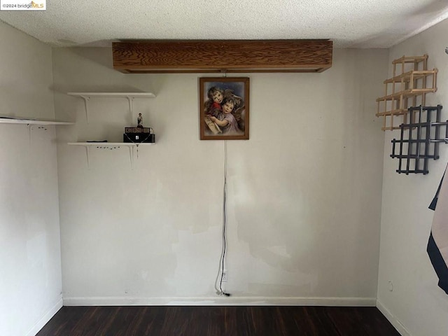 interior space with a textured ceiling and dark hardwood / wood-style floors