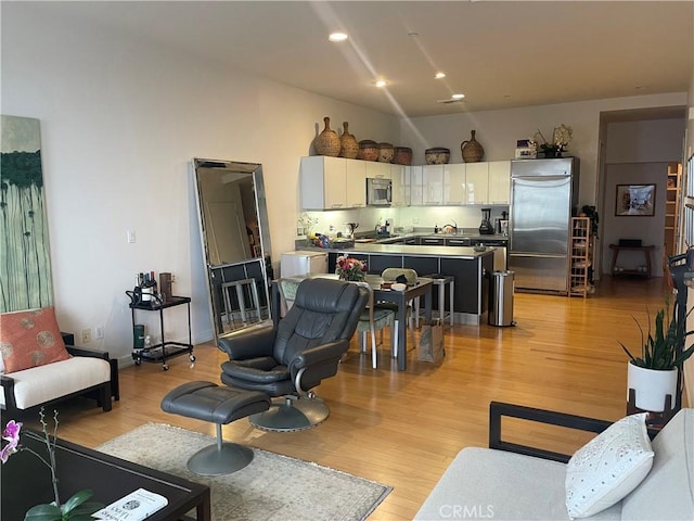 living room with light wood-type flooring and sink